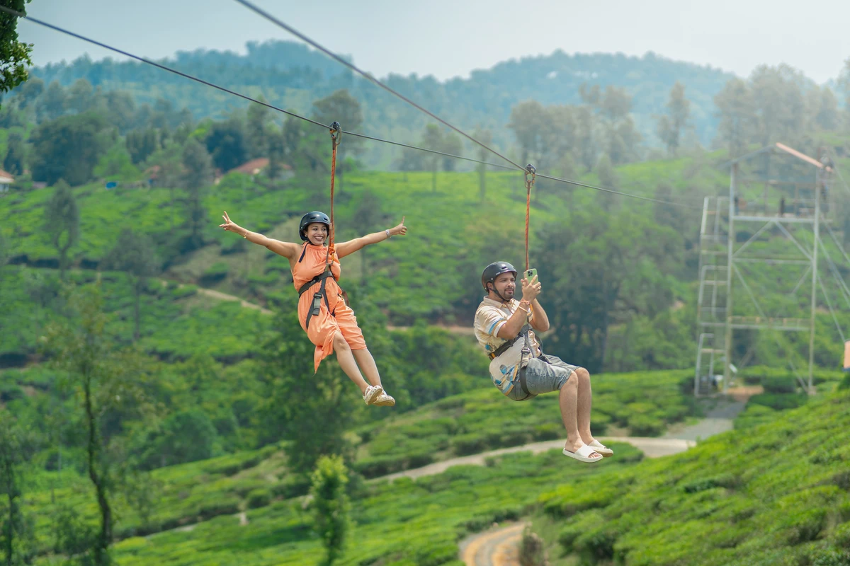 Tourist enjoying zipline wayanad activity flying over tea plantation resort wayanad Tourist enjoying zipline wayanad activity flying over tea plantation resort wayanad