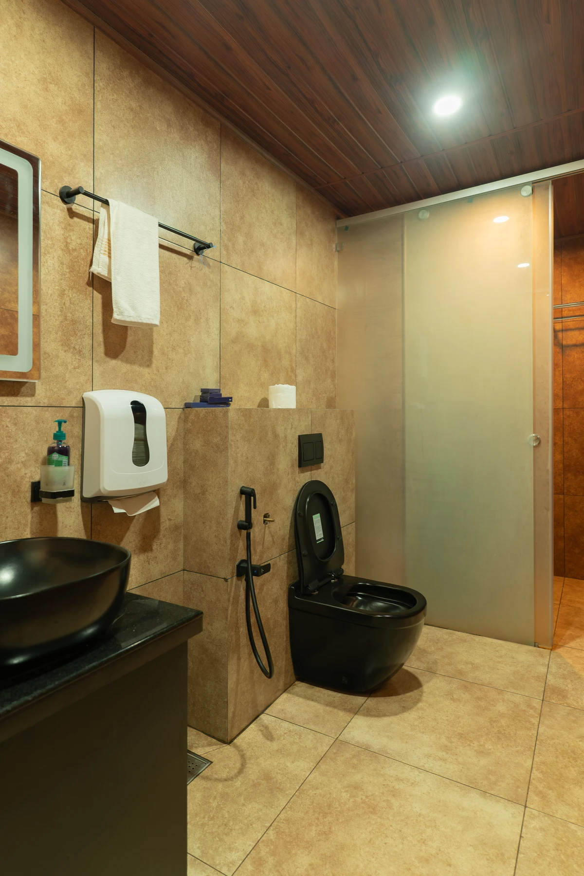 Modern Shower Panel & Textured Tiles Modern shower area with a sleek black shower panel and textured tiles at boCHE 1000 Acre, one of the best resorts in Wayanad.