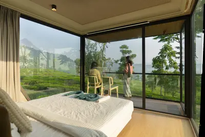 Luxury double bed with floor-to-ceiling plantation views inside xpod boche 1000 acre resort wayanad
