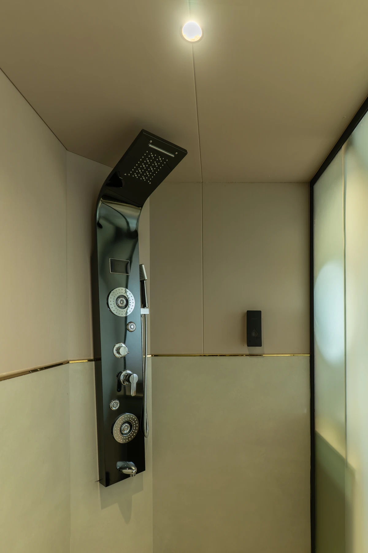 Multi-Function Shower Panel Sleek black multi-function shower panel in a modern stall at boCHE 1000 Acre, one of the best resorts in Wayanad.