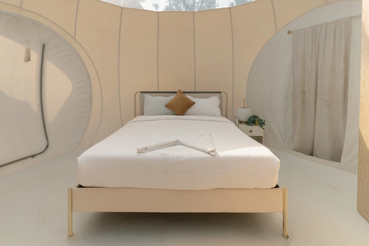 Cozy Bed inside Bubble Dome Cozy premium bed setup inside a scenic glamping bubble dome at boCHE 1000 Acre resort in Wayanad.