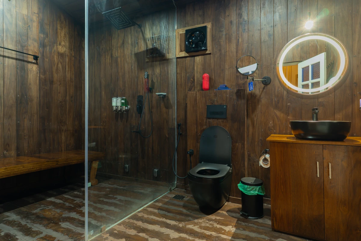 Modern Wooden Bathroom Suite Modern wooden bathroom with a glass shower and LED mirror at boCHE 1000 Acre, one of the best resorts in Wayanad.