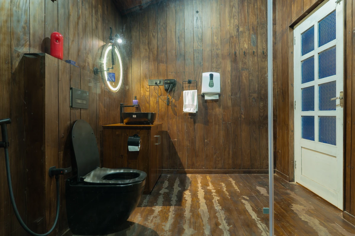 Bathroom Suite with LED Mirror Modern wooden bathroom with a glass shower and LED mirror at boCHE 1000 Acre, one of the best resorts in Wayanad.