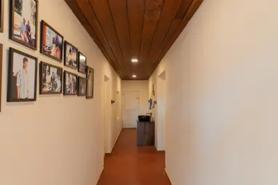 Elegant hallway with a photo gallery wall and wooden ceiling at boCHE 1000 Acre, one of the best resorts in Wayanad.