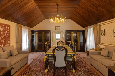 Elegant dining room with a luxury glass table and chandelier at boCHE 1000 Acre, one of the best resorts in Wayanad.