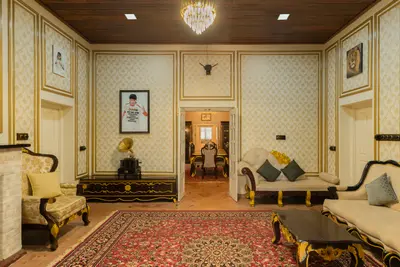 Royal living room with luxury antique-style furniture and a large carpet at boCHE 1000 Acre, one of the best resorts in Wayanad.